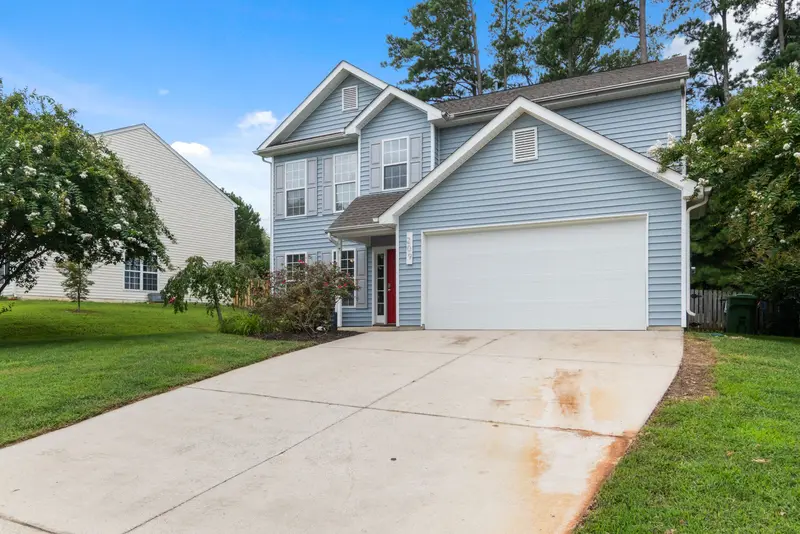 Garage door replacement: wide white garage door on a suburban house
