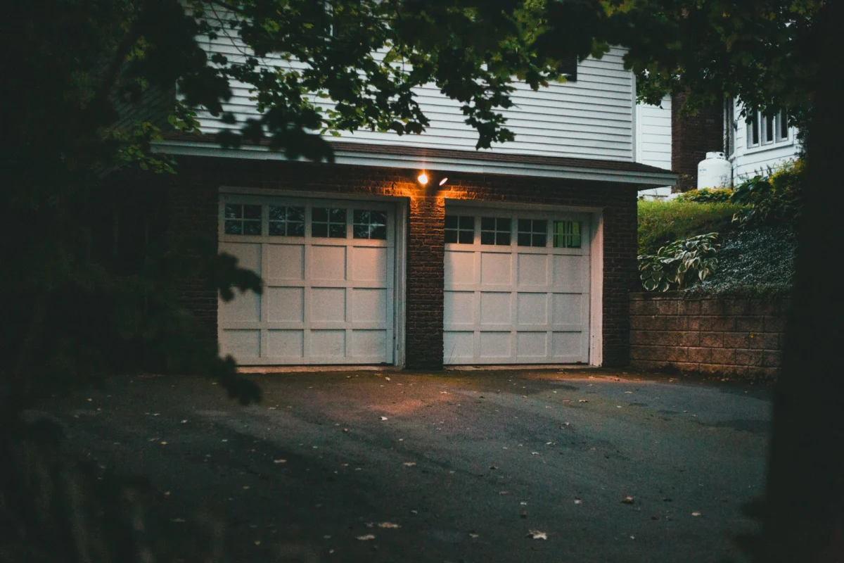 A two-car residential garage with brick detailing at twilight