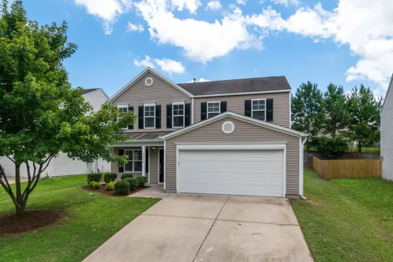 Two-story suburban home with an attached garage door and concrete driveway