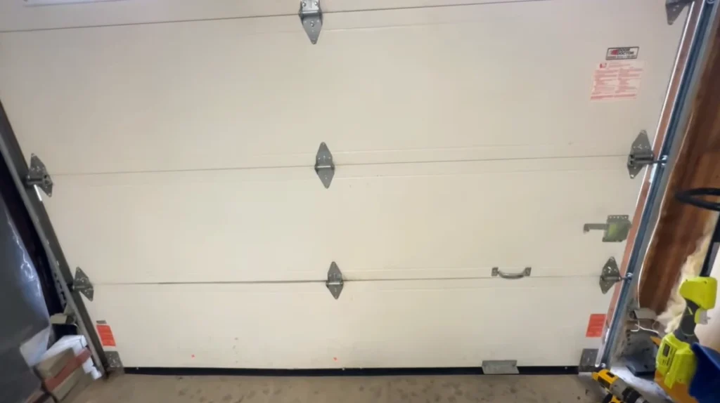 White residential garage door with clean panels, a common style for garage door replacement and repair